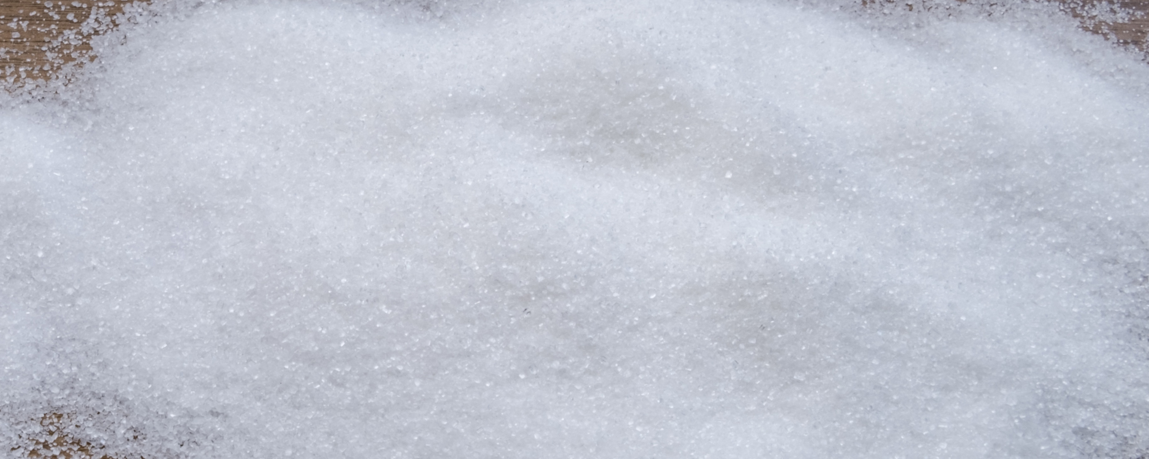 closeup of sugar spilled on table closeup of granulated sugar spilled on table